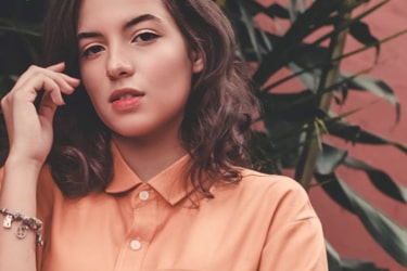 a female model posing in an orange button up shirt