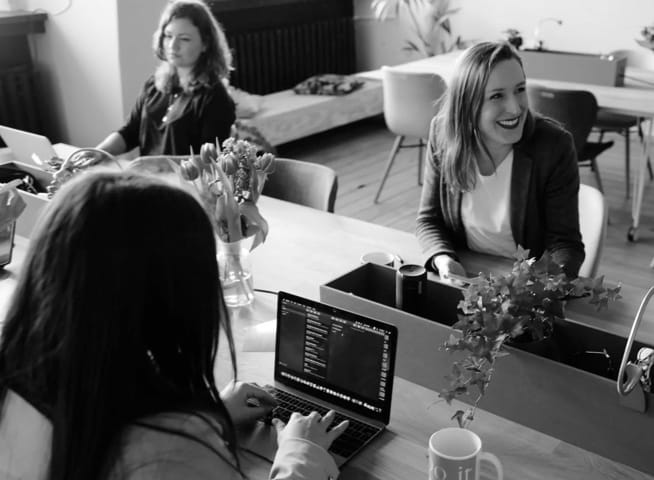 a group of people at a table working in an office