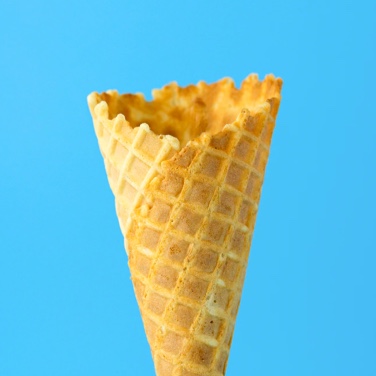 an empty ice cream waffle cone against a blue background